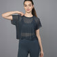 Woman in a Teal Netted Top and matching leggings poses in front of a plain gray background.