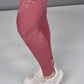 Person wearing Peony Pink Leggings with mesh cutouts and white sneakers, standing on a light gray surface.