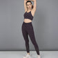 Woman wearing a Wine Netted Top and matching leggings with a honeycomb pattern, striking a pose against a gray background in white sneakers.