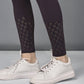 A person wearing white sneakers and black leggings with a cutout pattern near the ankles, paired with the Wine Netted Top.