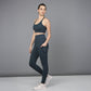 A woman poses against a gray background wearing the Teal Netted Top, honeycomb pattern leggings, and white sneakers.