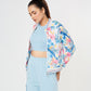 A woman stands against a white background wearing the Blossom Blue Set with Crop Top and cargo track pants.