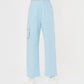 Person wearing the Blossom Blue Set with Crop Top, featuring light blue wide-leg pants with side pockets and white sneakers on a white background.