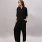 A woman models the Black Rayon Co-Ord Set, featuring a loose button-up shirt and relaxed-fit pants, against a light gray background.