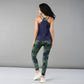 A woman stands with her back to the camera in a navy tank top and Tie & Dye Leggings, highlighting a stylish workout wardrobe crafted from stretchy fabric.