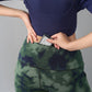 Person slipping a phone into the back pocket of Tie & Dye Leggings made from stretchy fabric, styled with a navy crop top.