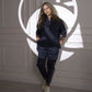 Wearing the Accented Set, a person stands against a wall with geometric light patterns, hands in pockets.