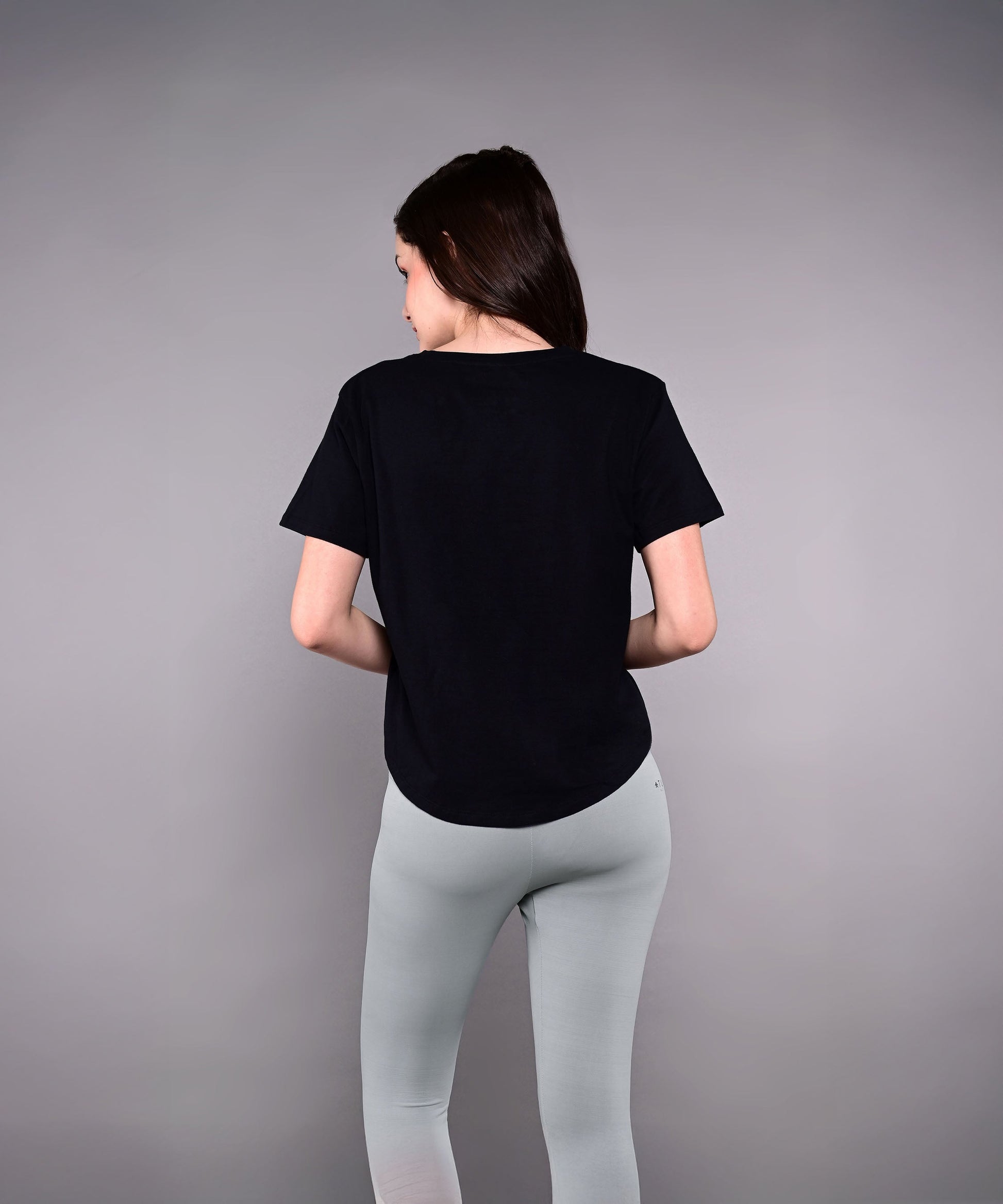 Model wearing a black Adore Your Core printed tee from Stylera with gray leggings