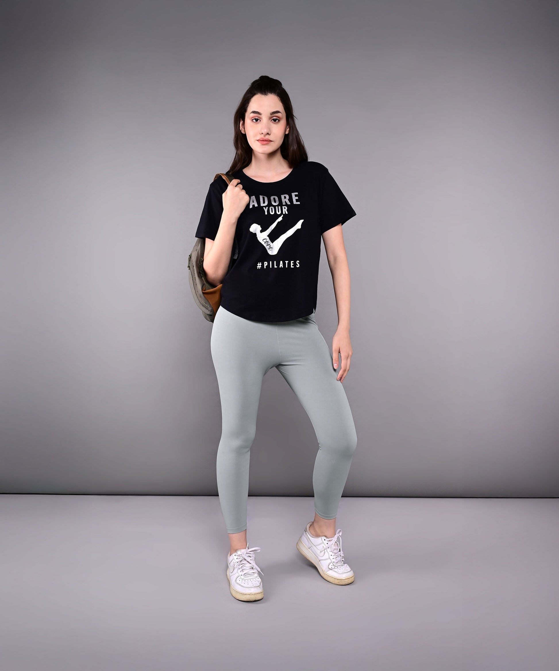 Woman in a black Adore Your Core printed tee and light leggings, perfect for workouts or casual wear