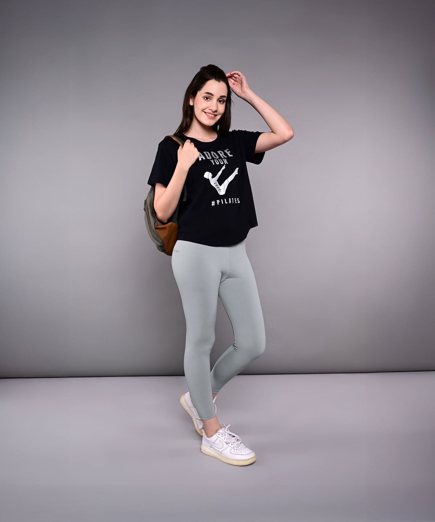 Model wearing Adore Your Core printed tee with gray leggings and a backpack for an active look