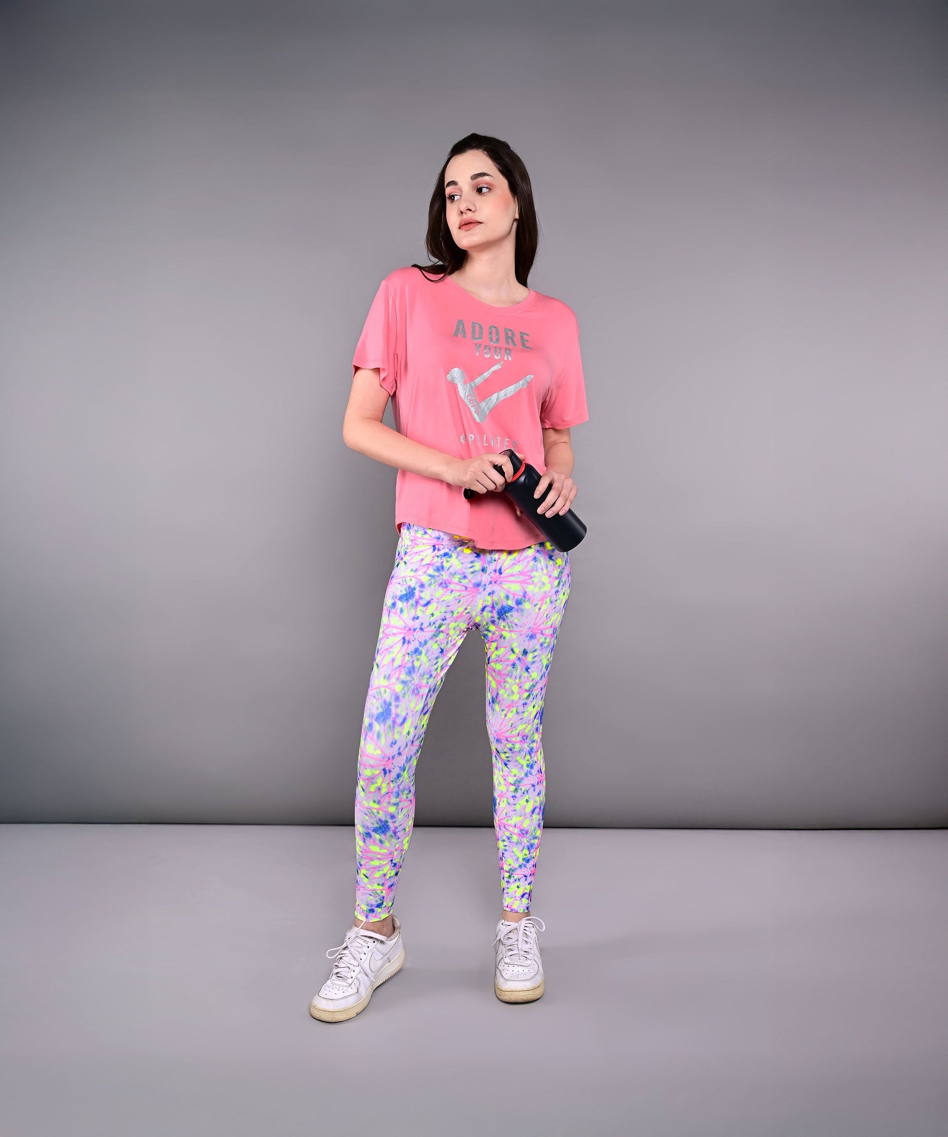 Model wearing Adore Your Core printed tee paired with colorful leggings and sneakers