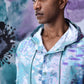 Stylera model wearing an artistic print hoodie shirt in pastel teal purple watercolor pattern