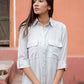 Model wearing an ash grey midi shirt dress with button-down closure and breast pockets