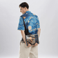 Back view of model wearing Stylera men's art print casual shirt with Starry Night design holding an art book