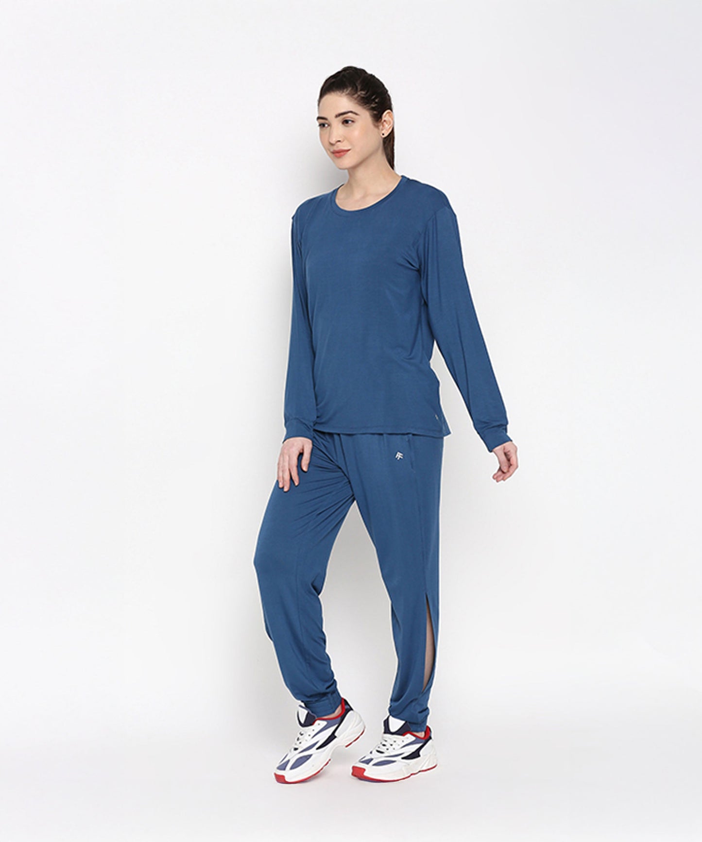 Model wearing an Atlantic blue activewear set featuring a long sleeve top and pants for comfortable workouts