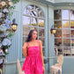 Woman in a hot pink Barbie balloon dress standing outside a mint cafe with floral decor