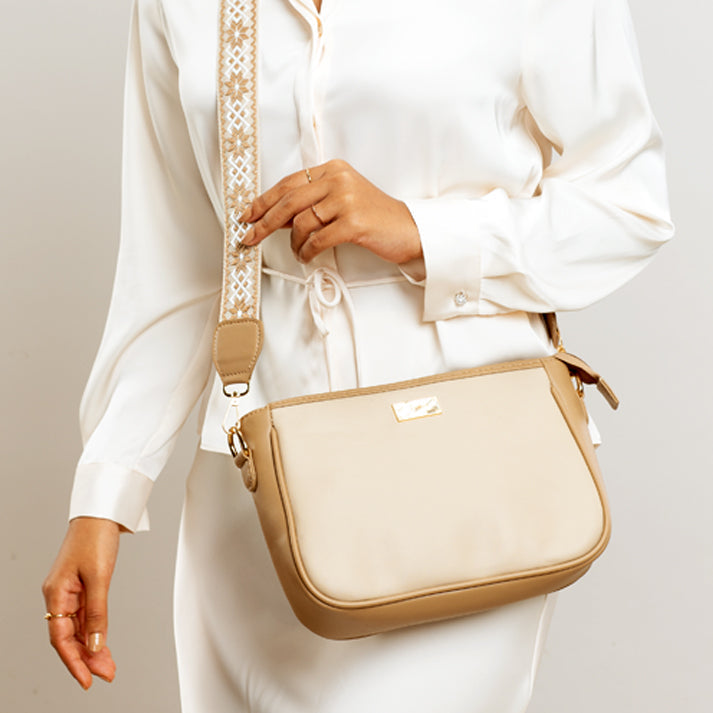 Beige crossbody purse with a stylish strap, perfect for everyday use and casual outfits