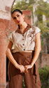 Stylera beige embroidered linen top with dark brown collar and buttons, styled with brown high-waist pants