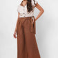 Stylera beige embroidered linen top with buttons worn by woman paired with brown wide-leg pants