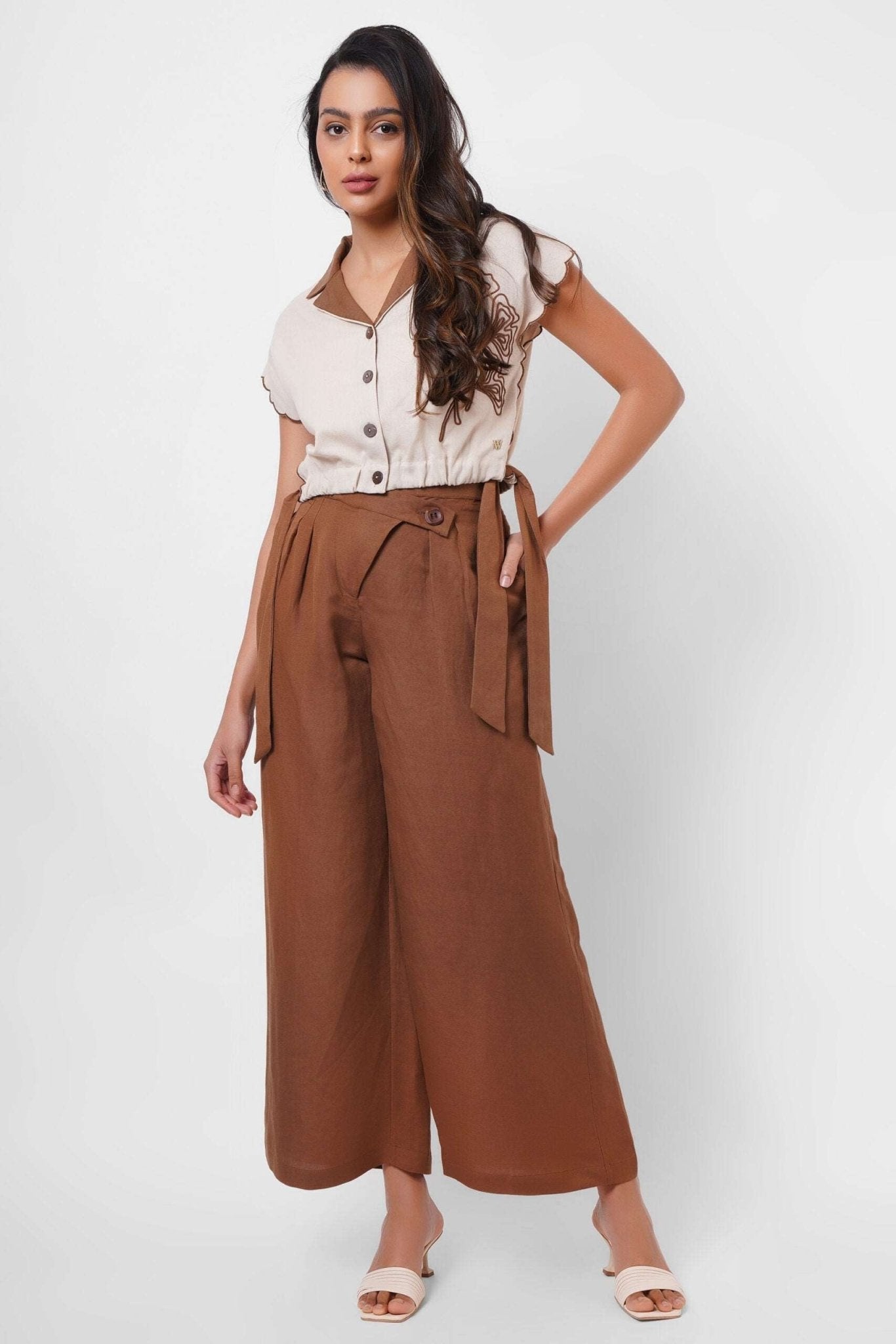 Stylera beige embroidered linen top with buttons worn by woman paired with brown wide-leg pants