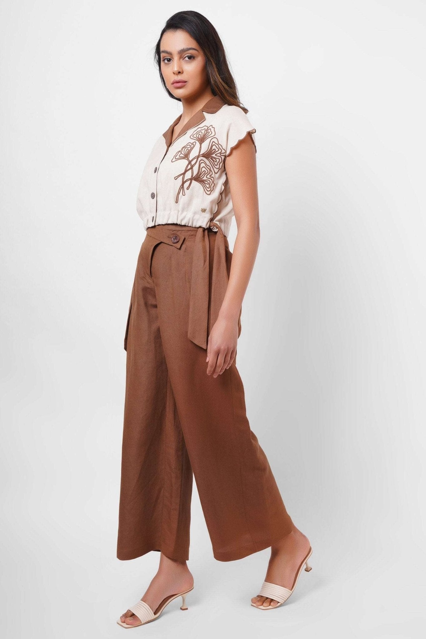 Stylera beige embroidered linen top with button front and floral design worn with brown wide-leg pants