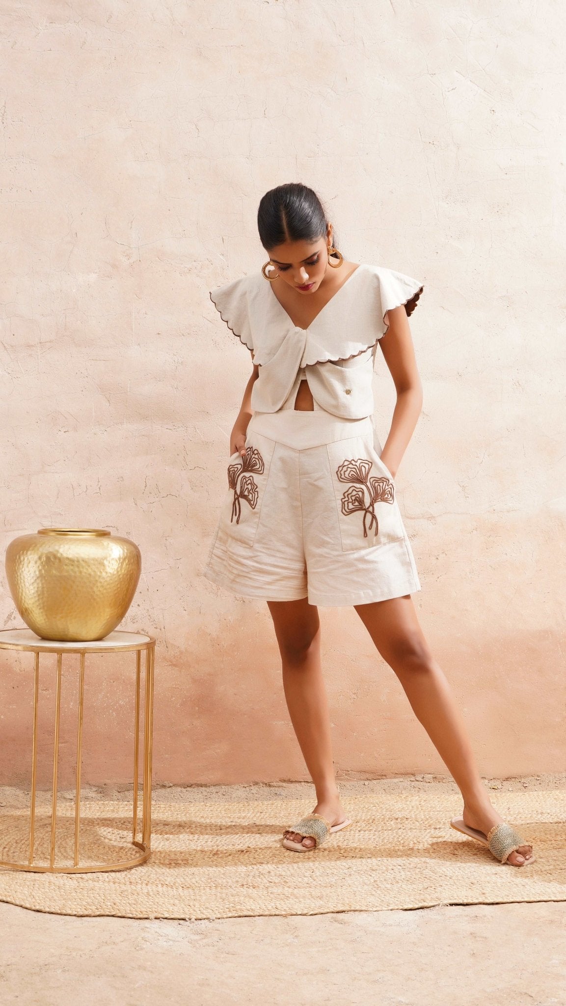 Stylera beige embroidered playsuit with floral designs and flutter sleeves styled with sandals