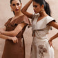 Stylera beige embroidered playsuit with floral design worn by model with gold hoop earrings