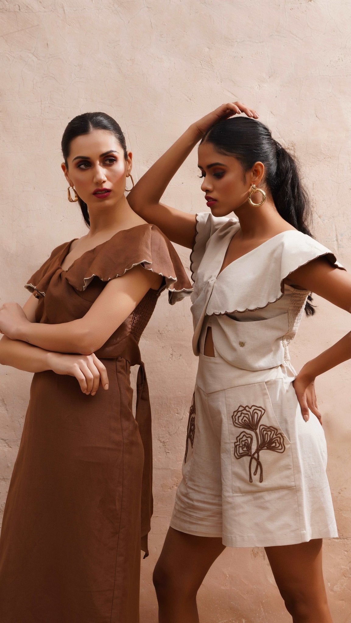 Stylera beige embroidered playsuit with floral design worn by model with gold hoop earrings