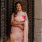 Elegant beige floral chiffon saree featuring vibrant pink flowers and intricate draping style