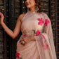 Elegant beige floral chiffon saree with vibrant pink flowers, perfect for festive occasions