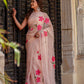 Elegant beige floral chiffon saree adorned with pink flowers, perfect for festive occasions