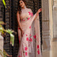 Elegant beige floral chiffon saree with vibrant pink flowers, perfect for special occasions