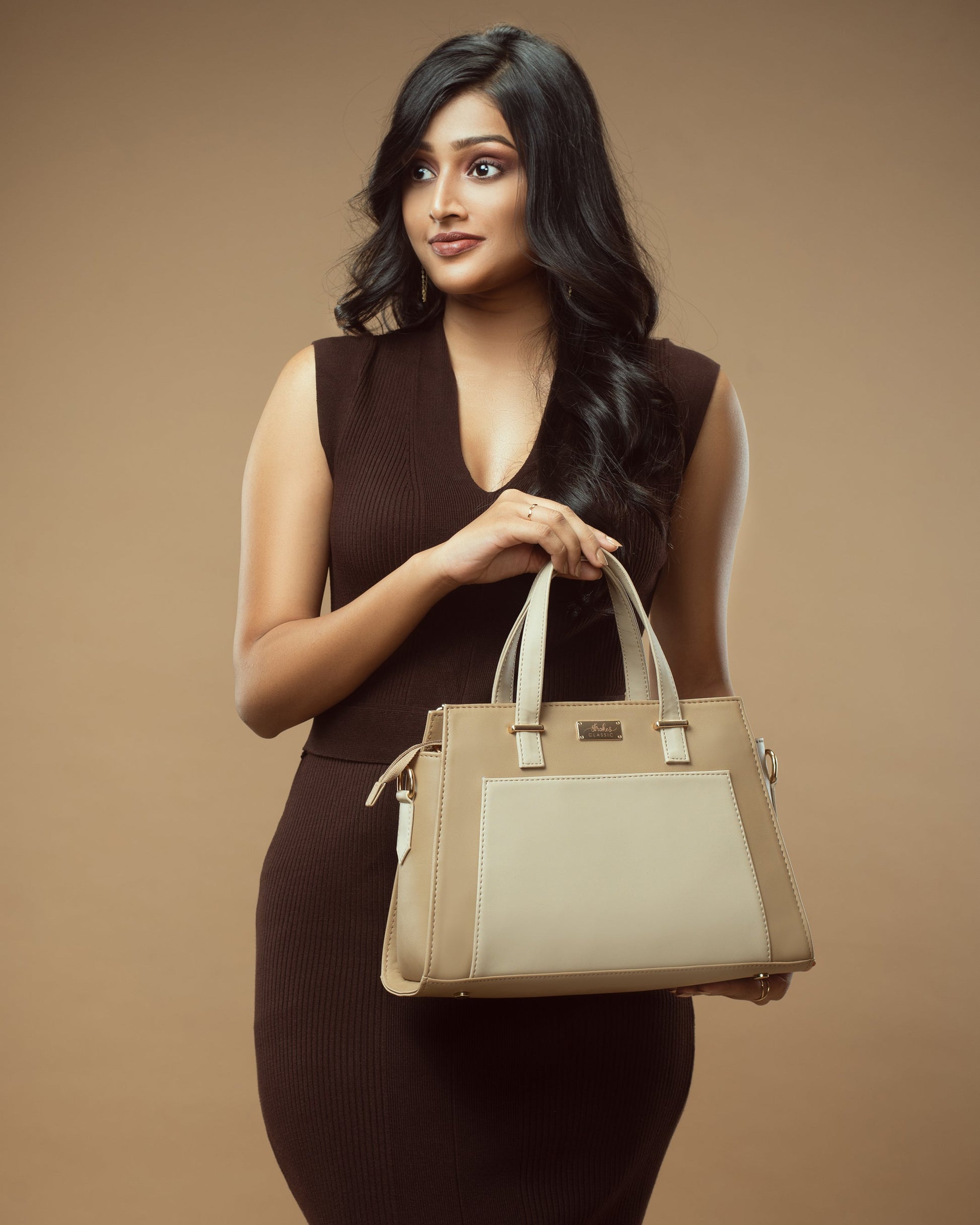 Stylish woman holding a beige luxury handbag for women with elegant design and premium materials