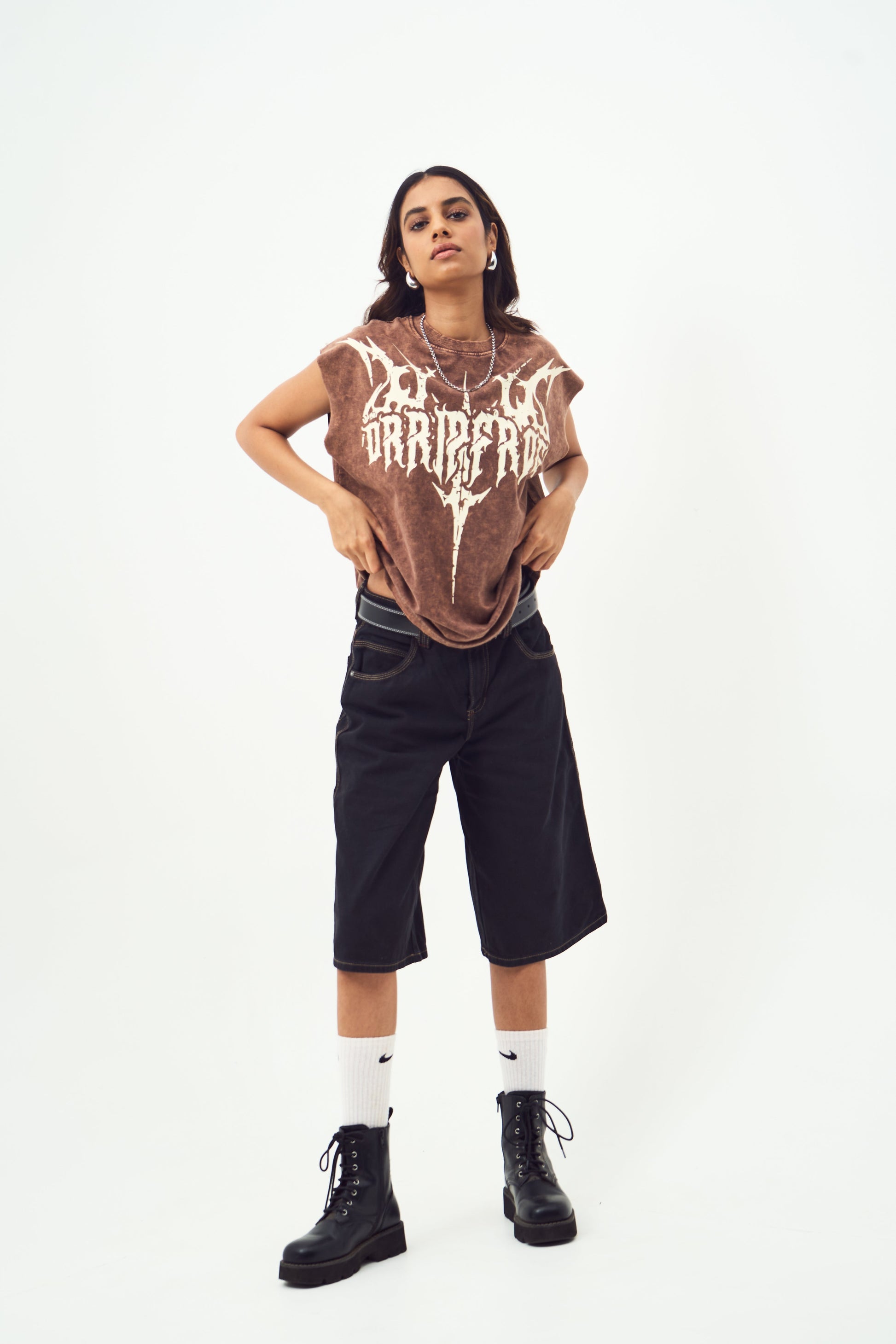 Model wearing Stylera beige print vintage style tee with black knee length shorts and boots