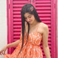 Model wearing Stylera Muse casual backless maxi dress in orange floral print with thin straps