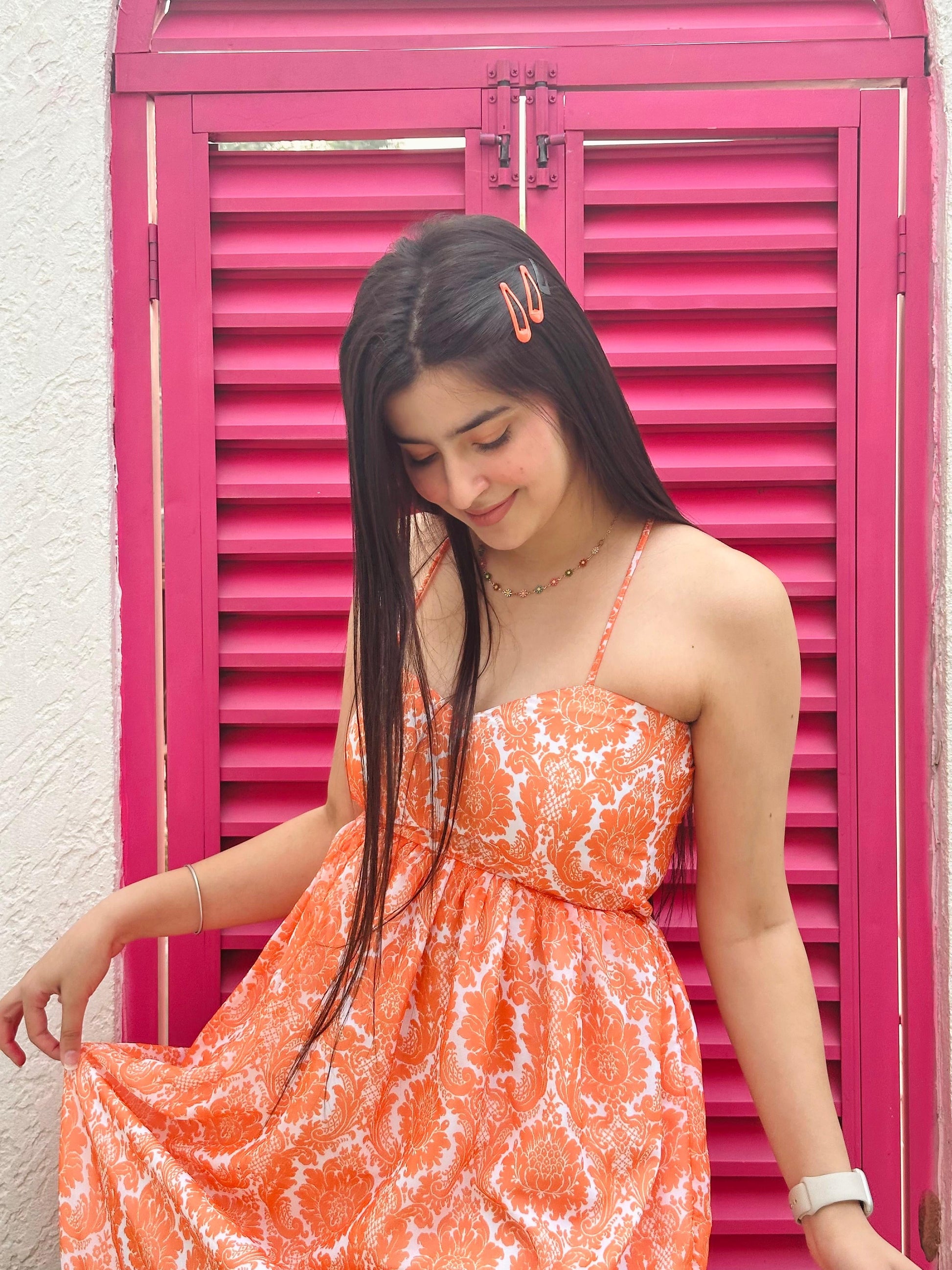 Model wearing Stylera Muse casual backless maxi dress in orange floral print with thin straps