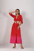 Stylera beach wear model wearing a stylish ombre skirt and top set red to pink tie front crop top with high slit skirt