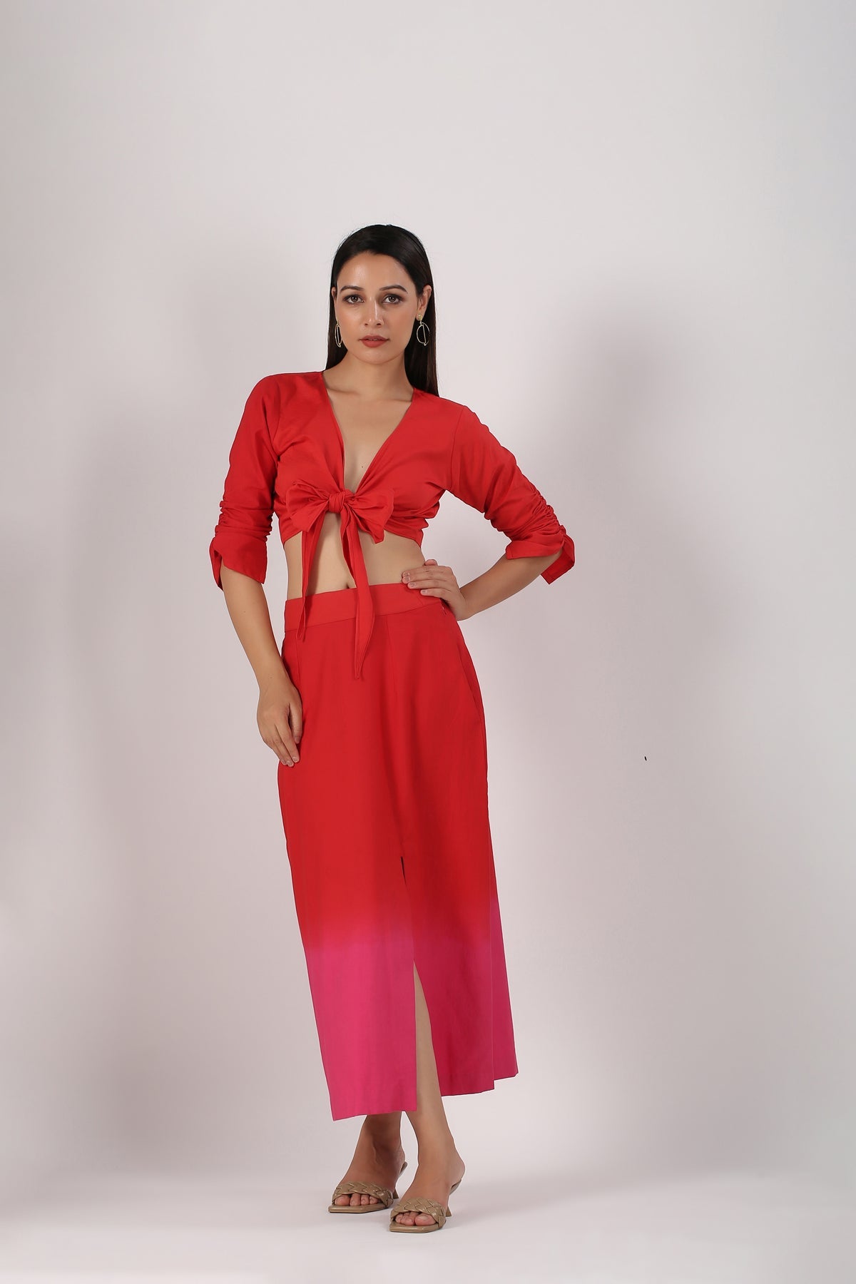 Stylera beach wear model in a stylish ombre skirt and top set red to pink tie front crop top and slit maxi skirt