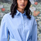 Model wearing Stylera unique casual light blue shirt for women with waist tie and button front