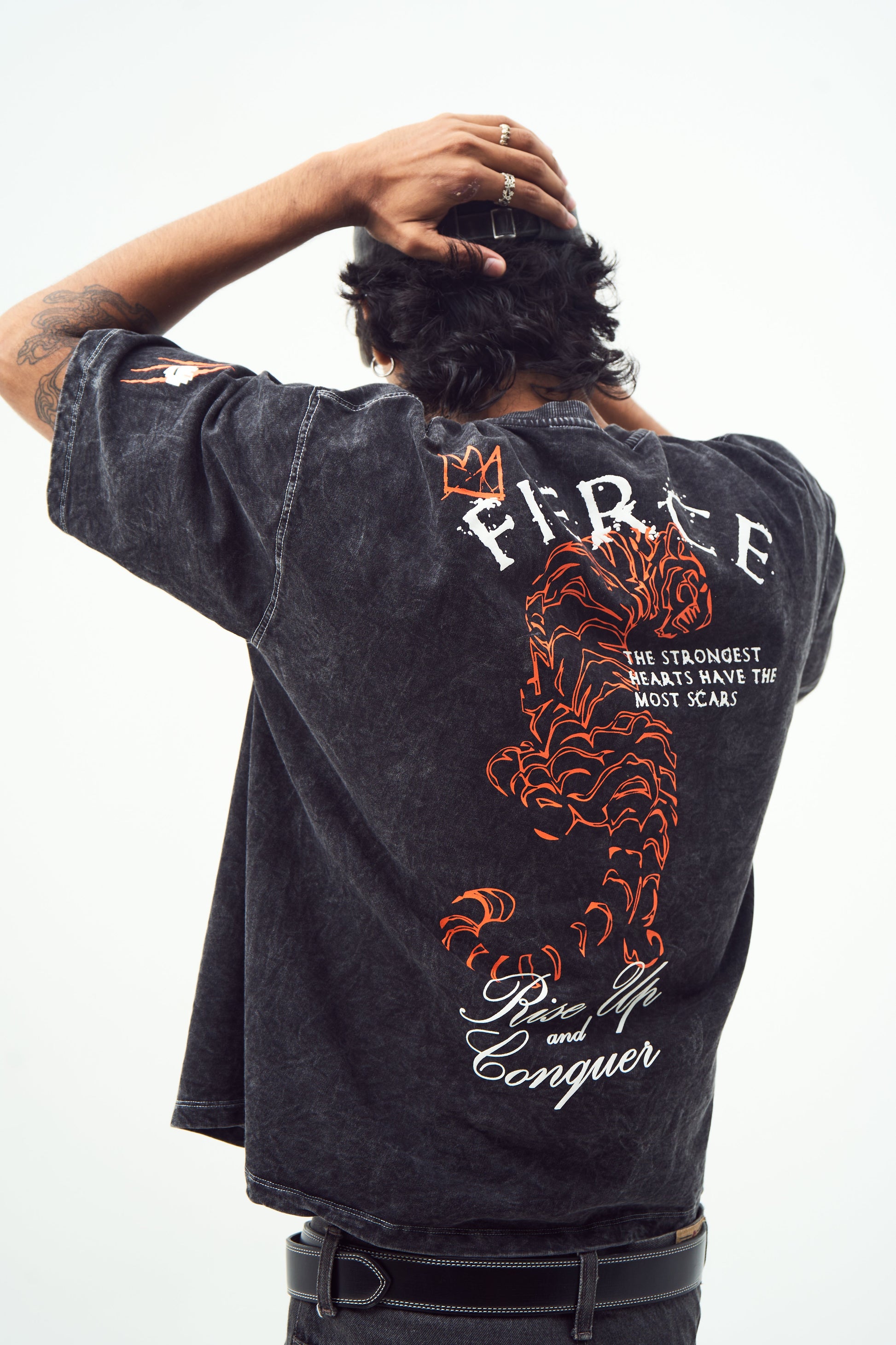 Model wearing black acid wash oversized t-shirt with red tiger back graphic crown and slogan