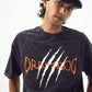 black acid wash oversized t-shirt Stylera logo with white claw marks and orange lettering modeled by young man wearing black cap