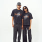 Male and female models wearing Stylera black acid wash oversized t-shirt with claw graphic paired with black pants
