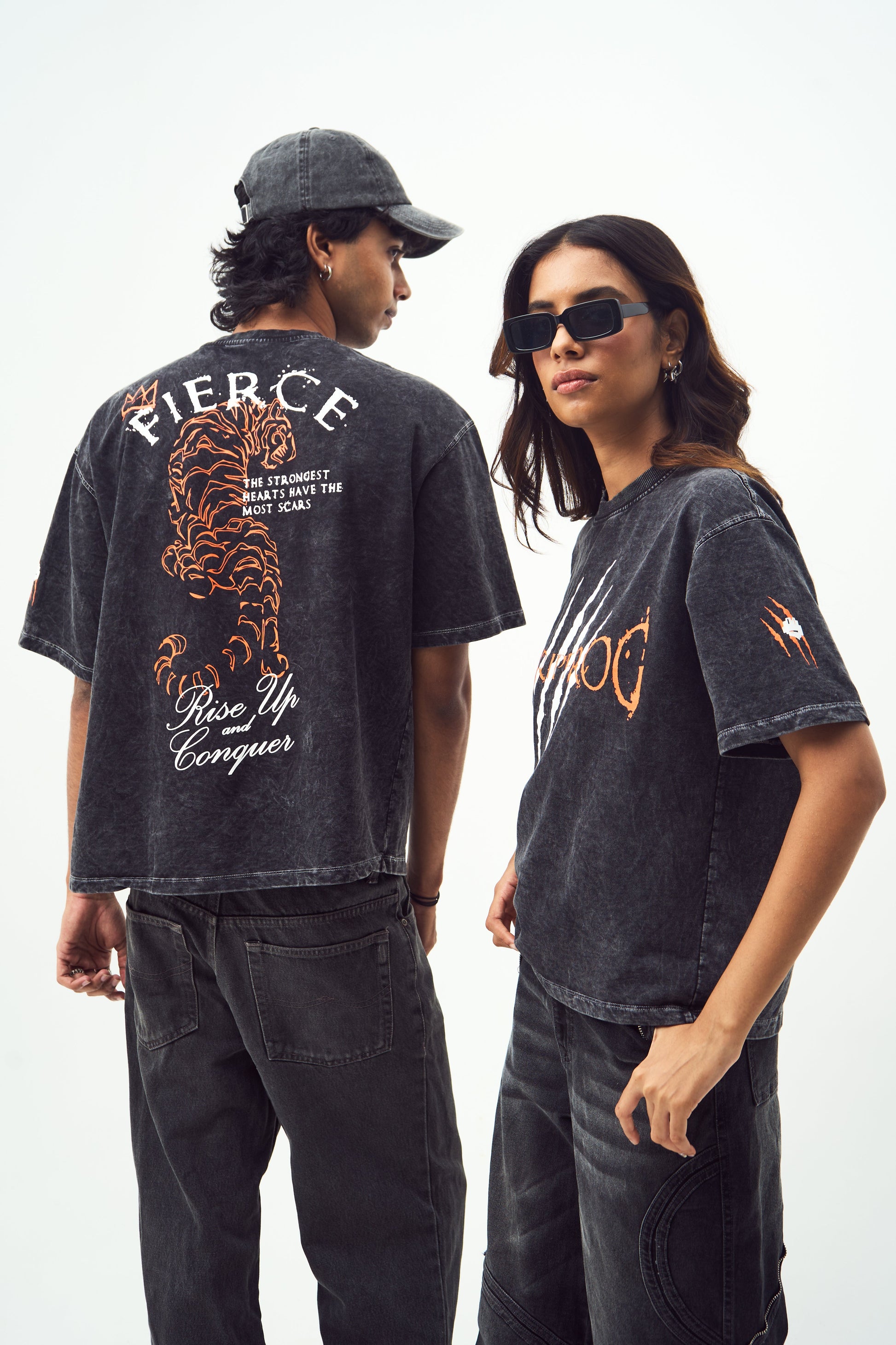 black acid wash oversized t-shirt on two models featuring tiger back print sunglasses cap and black jeans