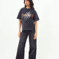 Model wearing Stylera black acid wash oversized t-shirt with claw logo paired with wide leg black jeans