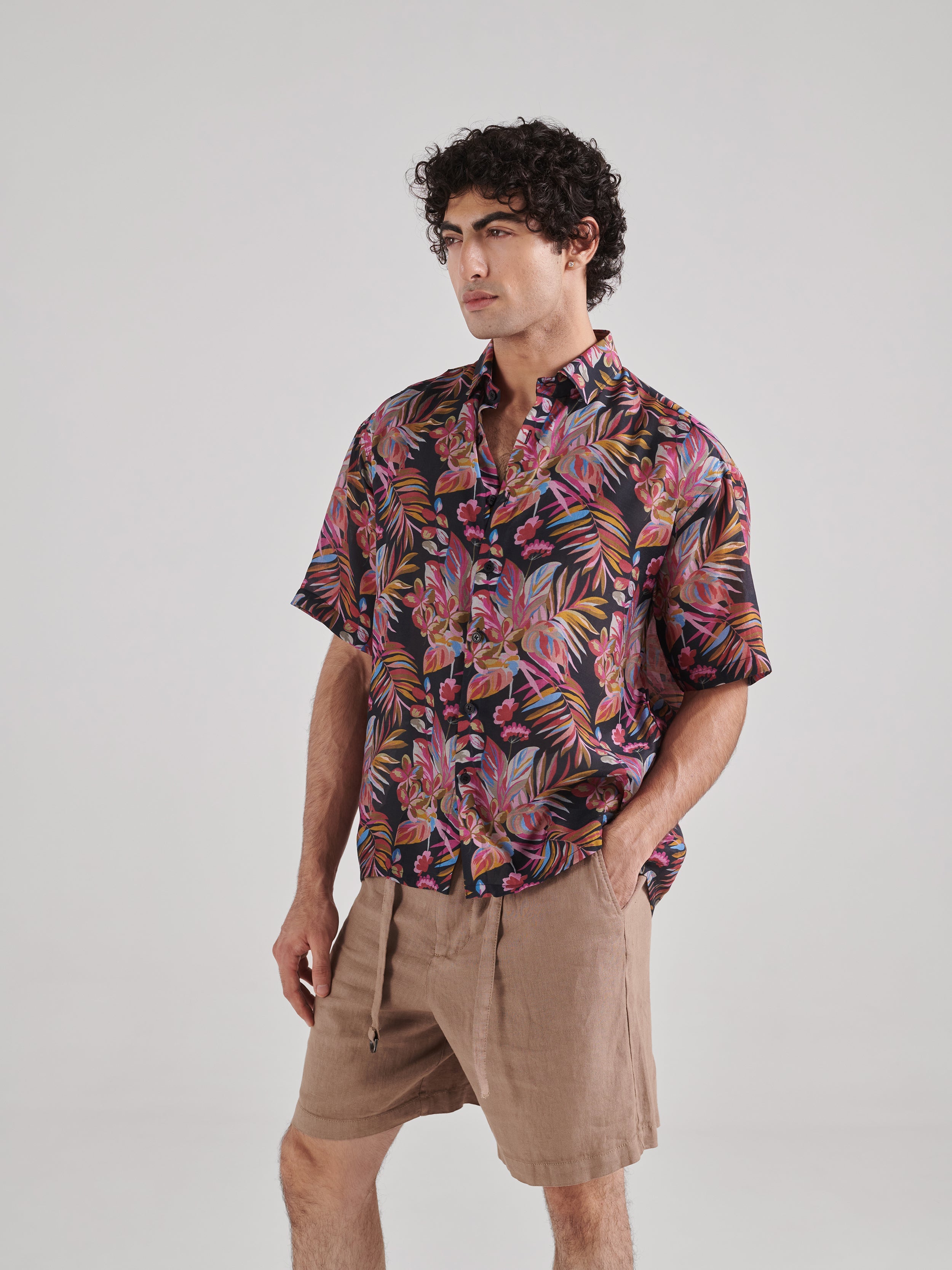 Black floral drop shoulder shirt from Stylera featuring vibrant tropical prints