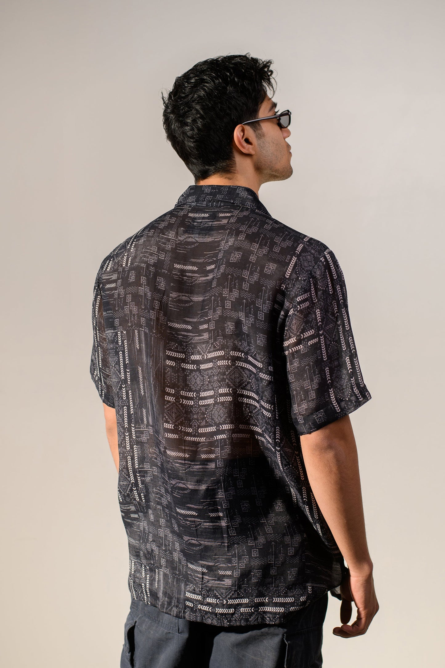 Back view of a black geometric silk shirt for men featuring a stylish pattern from Stylera