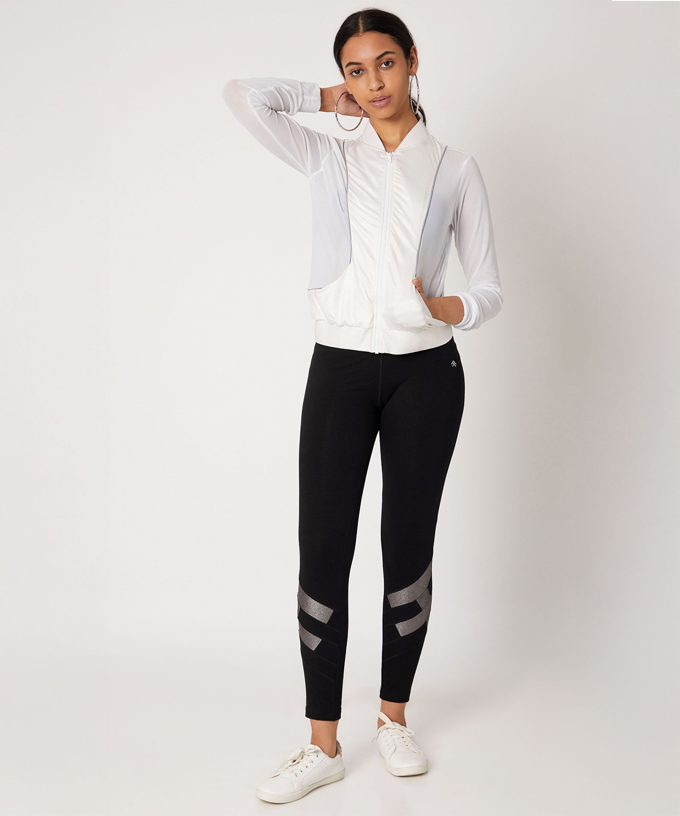 Black high waisted metallic leggings paired with a stylish white zip-up jacket for a sporty look