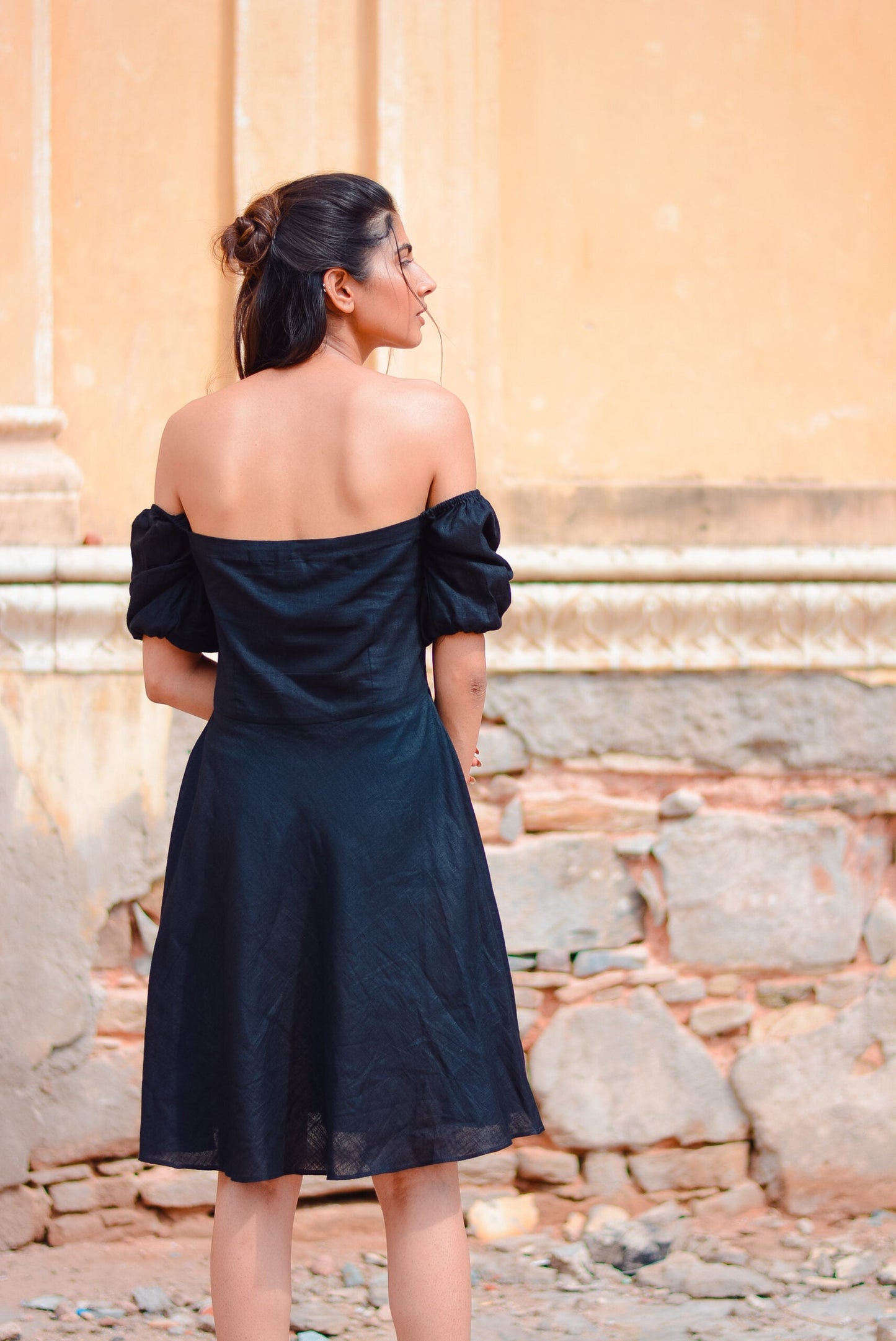 Back view of a black off shoulder short dress with puff sleeves, perfect for casual outings