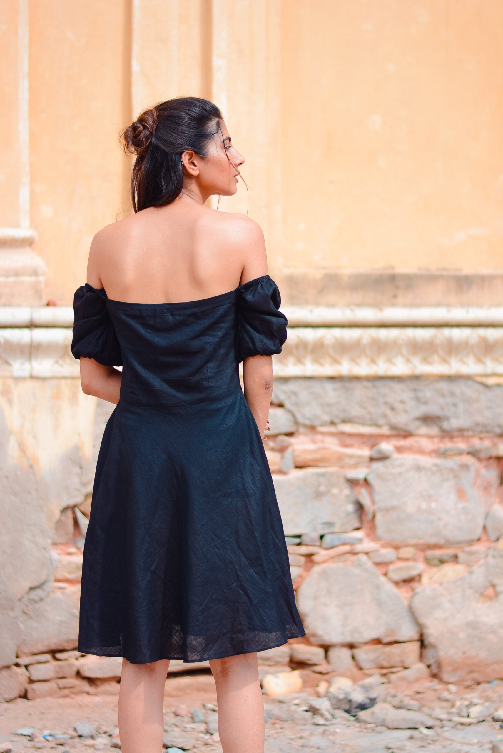 Back view of a black off shoulder short dress with puff sleeves, perfect for casual outings