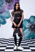 Model in black organza top for women layered over bandeau paired with shorts knee socks and white sneakers Stylera